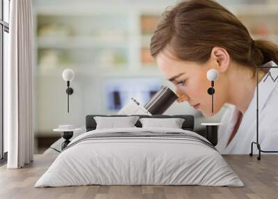 Young scientist working with microscope Wall mural