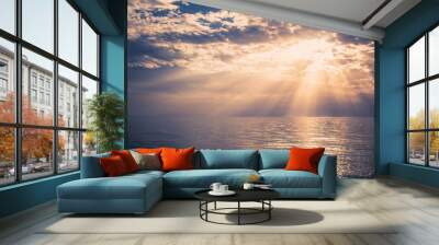 Beautiful sunset over the sea.
Sunbeams are shining through the clouds. Wall mural