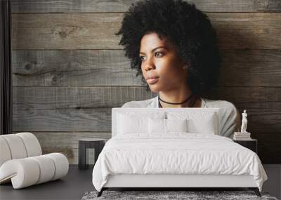 Beautiful young African woman, dressed casually, looking away at distance, posing with closed posture and thoughtful expression on her face, thinking about something while waiting for her friend Wall mural