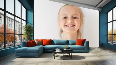 Close-up portrait of blond European little girl smiling with all her teeth. Happy kid in sunny afternoon makes every parent feel good. Childish smile is a source of positive emotions. Wall mural