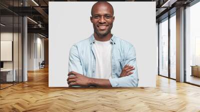 Horizontal shot of prosperous businessman keeps hands crossed, has satisfied expression, looks joyfully at camera, glad to achieve success, dressed in jean jacket, isolated over white background Wall mural