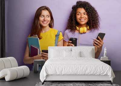 indoor shot of pleasant looking cheerful two mixed race groupmates have coffee break after lectures, Wall mural