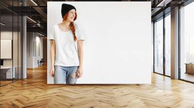 Isolated cropped portrait of fashionable stylish young woman model wearing trendy clothes looking away, laughing cheerfully while having fun indoors, posing at studio wall in trendy clothing Wall mural