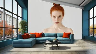 isolated portrait of beautiful young caucasian redhead woman with hair bun and perfect clean skin wi Wall mural