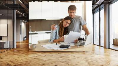 Negative human emotions. Financial problems. Portrait of unhappy young couple having looking worried while reading notification informing them about eviction from appartment because of unpaid bills Wall mural