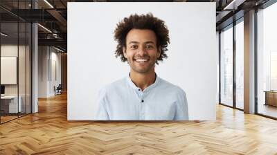 Positive guy with African hairstyle and dark skin wearing elegant white shirt looking cheerfully into camera isolated over white background. Young dark-skinned male with smile dressed elegantly Wall mural