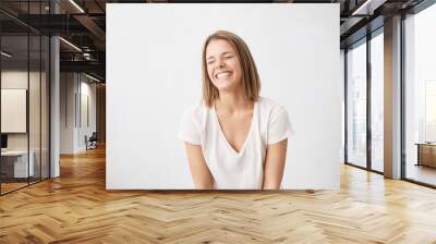 Positive human emotions. Headshot of happy emotional teenage girl with bob haircut laughing from the bottom of her heart, keeping eyes closed, showing perfect white teeth while having fun indoors Wall mural