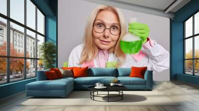 Professional chemist investigates someting new specialise in biochemistry develops drugs being highly technically skilled holds glassware with green liquid synthesizes or creats new substances Wall mural