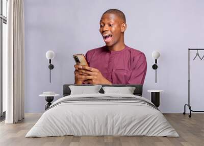 Happy black guy with mobile phone looking at smart phone with mouth wide open copy space, white background, panorama Wall mural