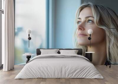 A businesswoman gazing out of a window searching for inspiration for a project Wall mural