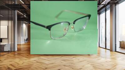 Stylish Black Frame Eyeglasses on Green Background Wall mural