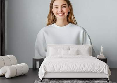 Casual young woman in a blank sweatshirt, smiling, isolated on light gray, perfect apparel mockup for branding or graphic design Wall mural