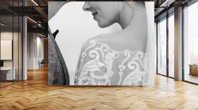 Black and white wedding photo. Groom kisses bride on forehead. Stylish newlyweds Wall mural