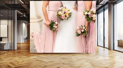 Bride and bridesmaids in pink dresses having fun at wedding day. Happy marriage and wedding party concept Wall mural