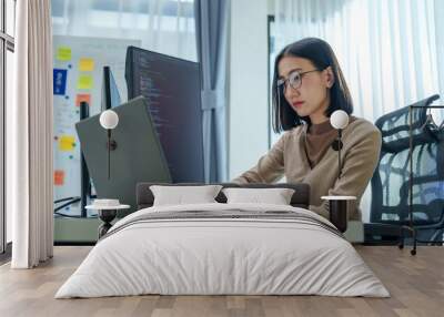 Asian prompt engineer develop coding app with software data sitting in front of computer monitor at office Wall mural