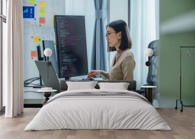 Asian prompt engineer develop coding app with software data sitting in front of computer monitor at office Wall mural