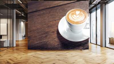 Close up hot cappuccino white coffee cup with heart shape latte art on dark brown old wood table at cafe,food and drink concept. Wall mural