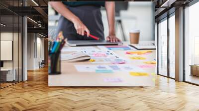 Close up ux developer and ui designer brainstorming about mobile app interface wireframe design on table with customer brief and color code at modern office.Creative digital development agency.panning Wall mural