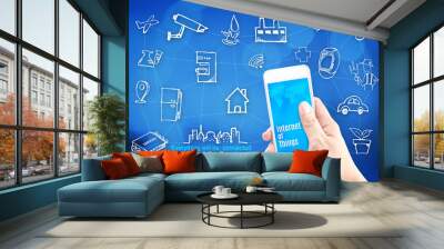 Hand holding smart phone with Internet of things (IoT) word and Wall mural