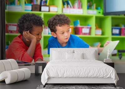 two boy kid lay down on floor and reading tale book in preschool library,kindergarten school educati Wall mural