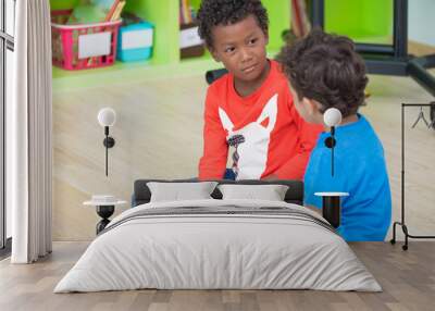 Two boy kid  sitting on floor and taking in preschool library,Kindergarten school education concept.diversity children. Wall mural