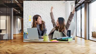 two colleague businesswoman arms up for good news from job on laptop about work at office.digital bu Wall mural