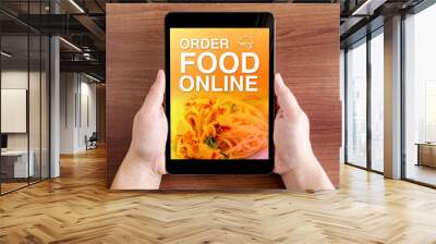 Two hand holding tablet with Order food online and icon on scree Wall mural