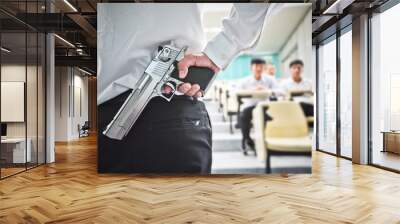 A lecturer holding a gun in his hand in a lecture room / Armed campus concept Wall mural