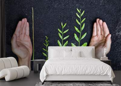 hands holding tree arranged as a green graph on soil Wall mural