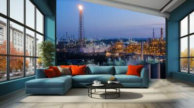 Oil and gas refinery industrial plant with flare stack on blue sky twilight background Wall mural