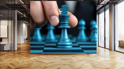 A hand moves a blue chess piece on a modern chessboard, symbolizing strategy, intelligence, and competition in a game. Wall mural