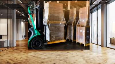 Worker driving forklift loading and unloading shipment carton boxes and goods on wooden pallet from container truck to warehouse cargo storage in logistics and transportation industrial  Wall mural