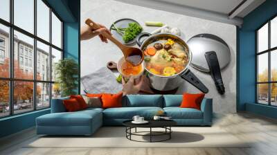 The scene of using a pressure cooker to make soup and cook dishes in the kitchen, marble countertop background, wood grain desktop Wall mural