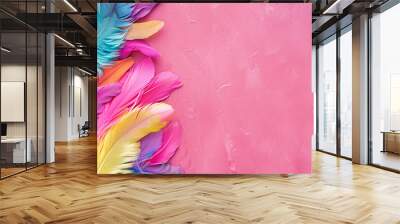 Colorful feathers on a pink background in a top view. Mardi Gras concept with space for copy text or design. Flat lay. Vibrant color scheme with many bright, colorful and saturated colors. Wall mural