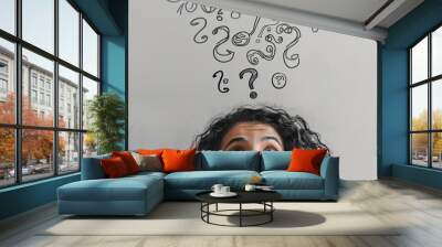 Woman thinking with question marks floating above her head on light grey background, banner design Wall mural