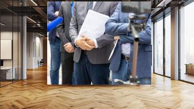 Lawyer or attorney holding documents, giving statement at news conference Wall mural