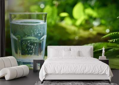 a glass of cool fresh water on natural green background Wall mural