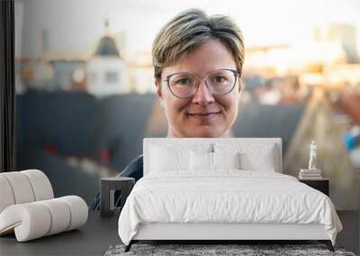 Outdoor portrait of a 38 yo white woman on a rooftop with old town in the background, Belgium Wall mural