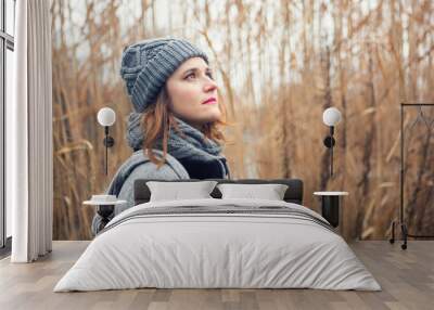 portrait of young woman outdoors with reeds in the background Wall mural