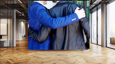 two businessmen hugging each other outdoor Wall mural