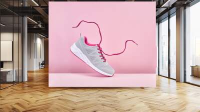 Pair of fashion stylish sneakers with flying laces, Running sports shoes on pink background Wall mural