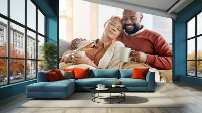 Black couple relax on sofa with coffee, blanket and smile on winter weekend morning in home. Peace, comfort and love, happy man and tired woman, cozy time on couch with drink in living room together. Wall mural