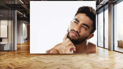 Confused, thinking and face of man in studio for wellness, skincare and hygiene on white background. Doubt, portrait and indian male model with unsure emoji contemplating beauty cosmetic or body care Wall mural