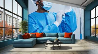 Doctor in surgery, man in healthcare and surgical procedure start with PPE for safety in operation theatre in hospital. Medical professional, health insurance and male surgeon in protection gear Wall mural