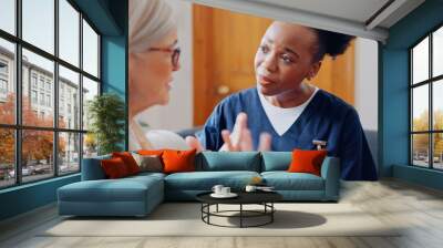 Frustrated, sad woman speaking or nurse with results in consultation for bad news or cancer. Stress, lady talking or caregiver with a depressed mature patient for empathy, sympathy or help in home Wall mural