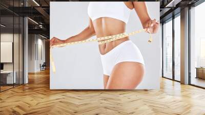 Health, wellness and woman with measuring tape on waist, healthy diet and exercise for body care. Fitness, nutrition and flat stomach, girl tracking weight loss progress isolated on white background. Wall mural