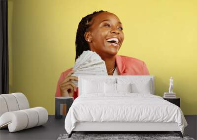 Money, fan and winner with a black woman in studio on a yellow background holding cash, finance or wealth. Financial, investment and trading with dollar bills in the hand of a female after winning Wall mural