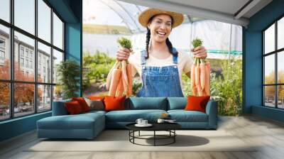 Greenhouse, portrait of happy woman holding carrots at sustainable small business in agriculture and natural organic food. Girl working at agro farm, vegetable growth in garden and eco friendly pride Wall mural