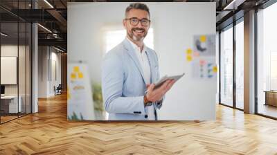 Portrait of mature man in office with tablet, smile and research for business website, online report or social media. Internet, digital app and businessman with workshop, web schedule and confidence. Wall mural