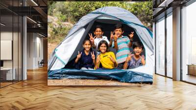 gorup of kids inside camping tent grimacing by looking at camera during summer camp of hill top - concpet of happiness, relaxing and vacation Wall mural